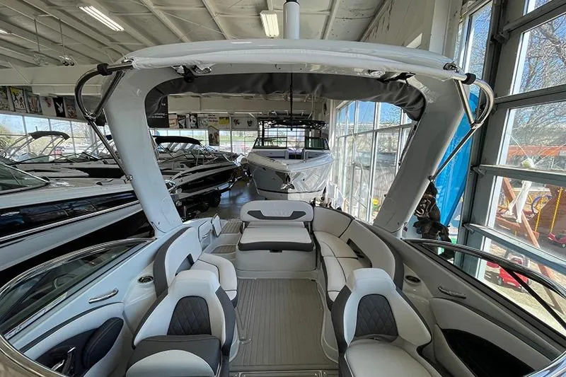Slide: The Image of 2024 Crownline 290SS boat interior in showroom, featuring sleek seating and modern design. - 5