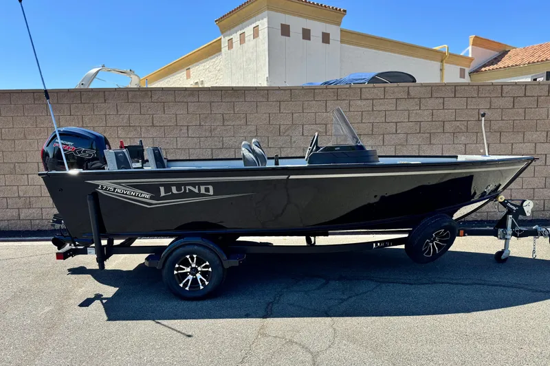 The Image of 2024 Lund 1775 Adventure Sport boat on trailer, parked outdoors. - 0