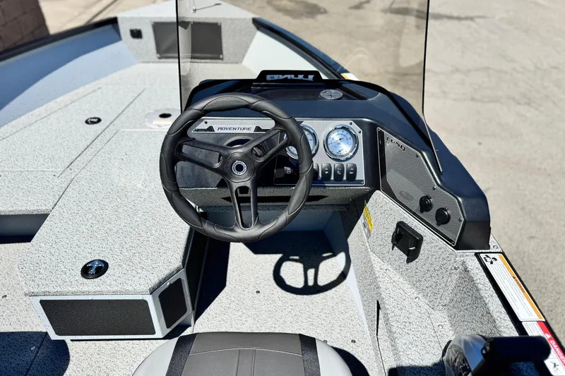 Slide: The Image of 2024 Lund 1775 Adventure Sport boat dashboard with steering wheel and gauges. - 18