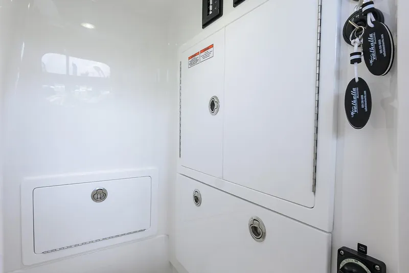 Slide: The Image of 2026 Valhalla V-29 interior storage compartments with sleek white finish and key fobs. - 26