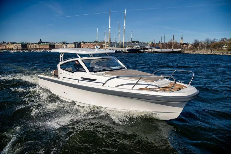 Slide: The Image of 2023 Nimbus W9 boat cruising on a sunny day in a scenic harbor. - 11