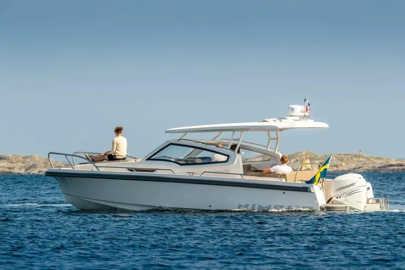 Slide: The Image of 2023 Nimbus W9 boat cruising on open water with passengers enjoying the ride. - 4