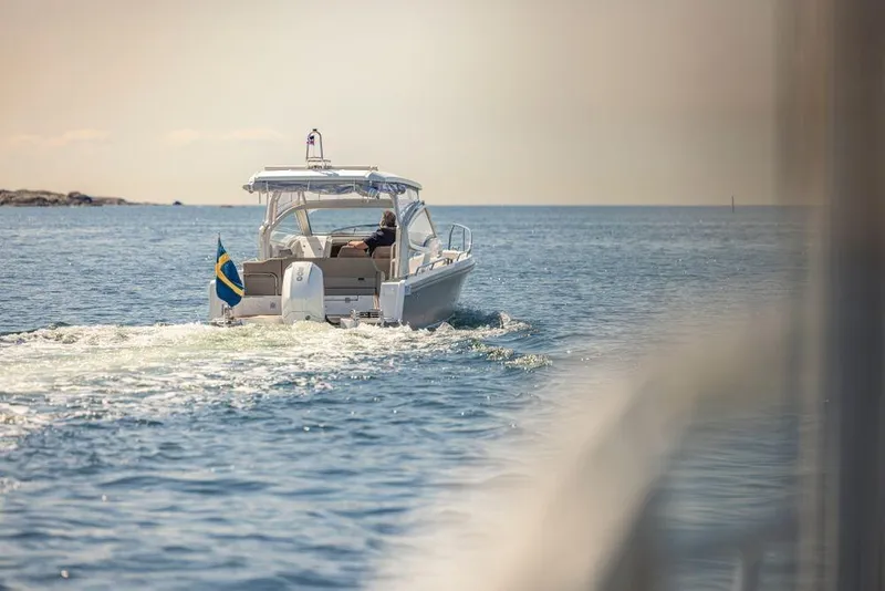Slide: The Image of 2023 Nimbus W9 boat cruising on open water with Swedish flag. - 15
