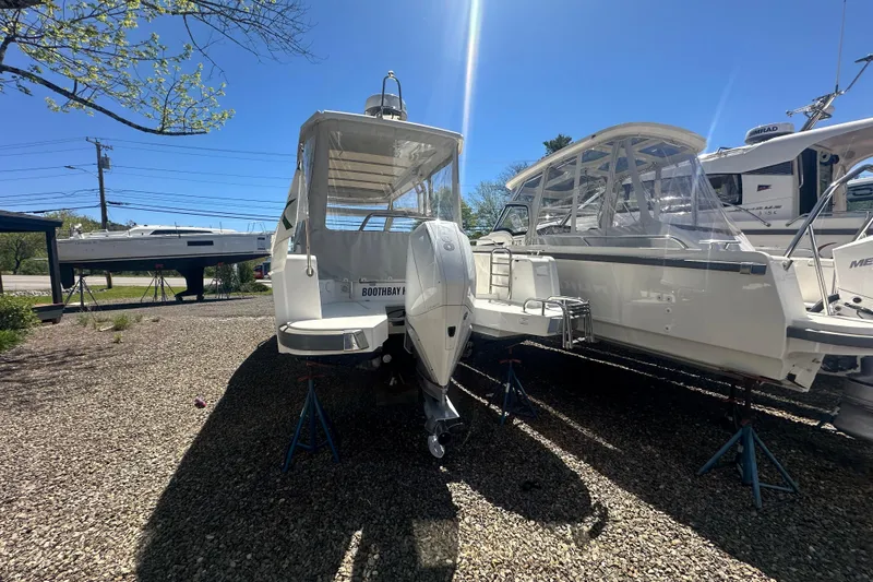 Slide: The Image of 2023 Nimbus Weekender 9 boat on stands under clear blue sky. - 23