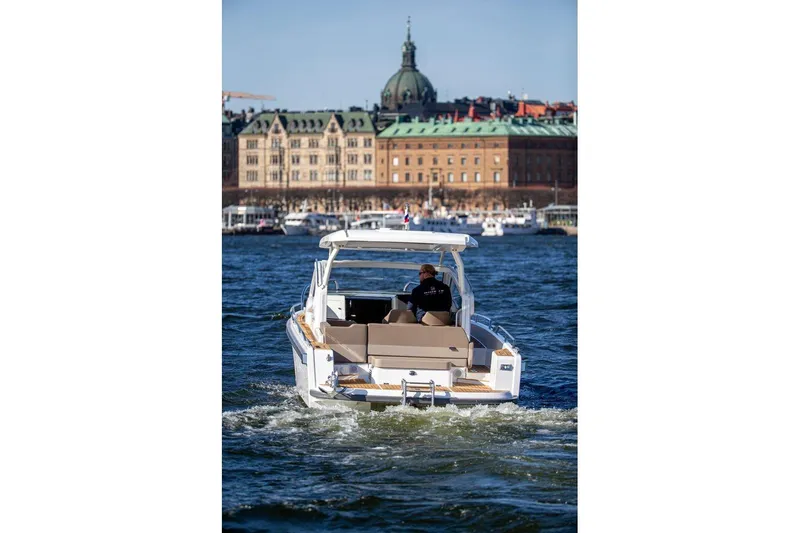Slide: The Image of 2023 Nimbus W9 boat cruising near historic waterfront buildings. - 8