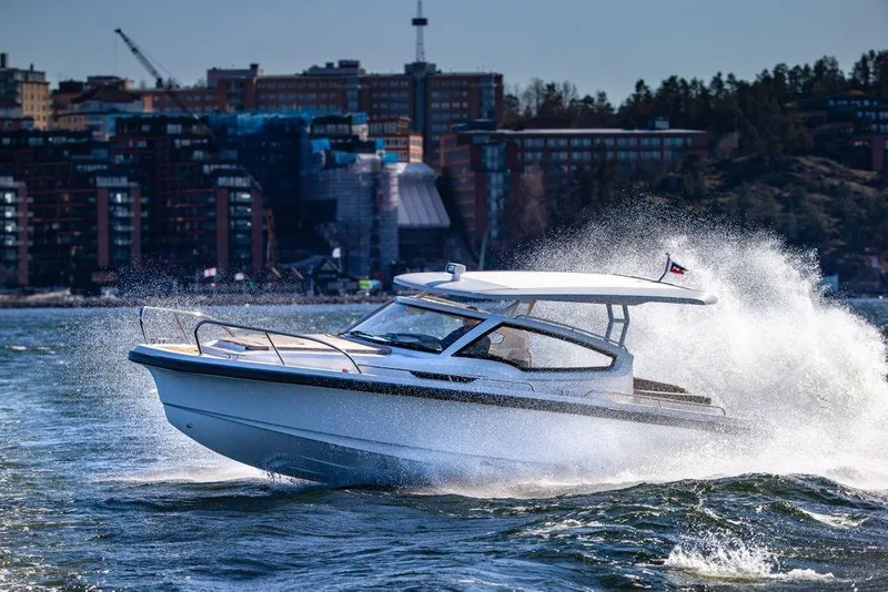 Slide: The Image of 2023 Nimbus W9 boat cruising on water with cityscape background. - 9