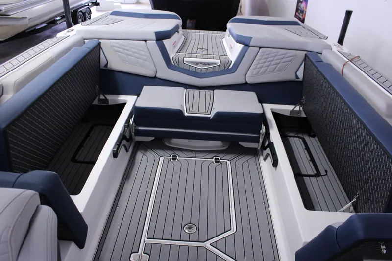 Slide: The Image of 2024 Nautique G25 boat interior with blue and gray seating and storage compartments. - 11