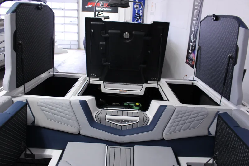 Slide: The Image of 2024 Nautique G25 boat interior with open storage compartments and quilted seating. - 12
