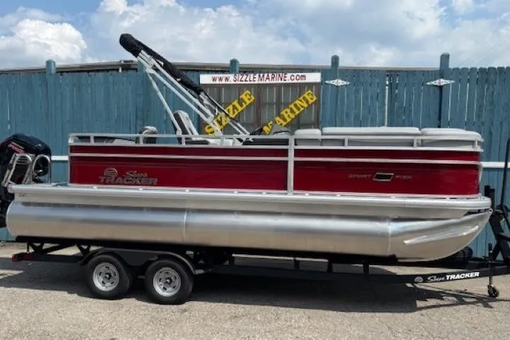 Slide: The Image of 2026 Sun Tracker SportFish 20 DLX pontoon boat on trailer, red and silver design. - 1