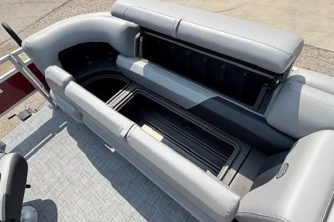 Slide: The Image of 2026 Sun Tracker SportFish 20 DLX pontoon boat with open storage compartments and gray seating. - 12
