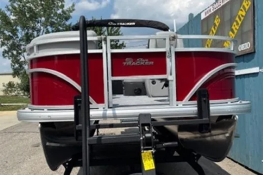 Slide: The Image of 2026 Sun Tracker SportFish 20 DLX pontoon boat with red exterior, displayed outdoors. - 2