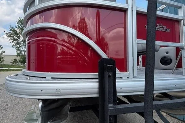Slide: The Image of 2026 Sun Tracker SportFish 20 DLX pontoon boat, red exterior, docked outdoors. - 3