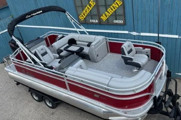 Slide: The Image of 2026 Sun Tracker SportFish 20 DLX pontoon boat with red and silver design, parked on trailer. - 8