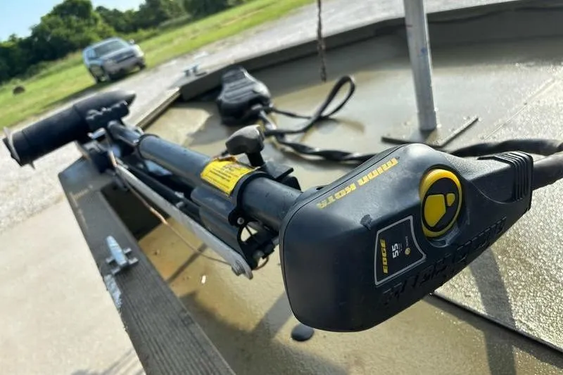 Slide: The Image of 2012 Tracker 1860 Grizzly boat with Minn Kota trolling motor in a grassy area. - 3