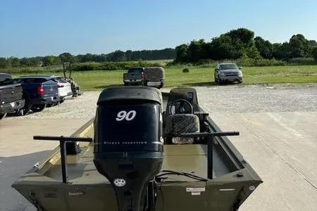 Slide: The Image of 2012 Tracker 1860 Grizzly boat with 90 HP motor in a parking lot. - 4