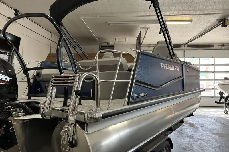Slide: The Image of 2024 Premier Sunsation 210RL pontoon boat in a garage, showcasing sleek design and modern features. - 1