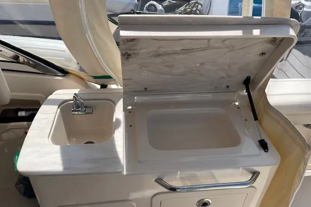 Slide: The Image of 2020 Grady-White Freedom 275 boat interior with sink and storage compartment. - 10
