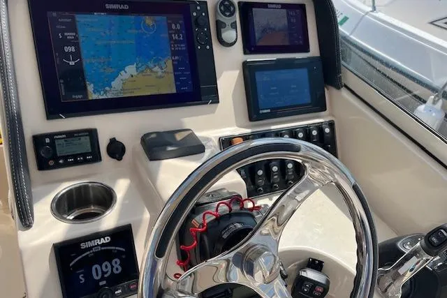 Slide: The Image of 2020 Grady-White Freedom 275 boat dashboard with Simrad navigation displays and controls. - 12