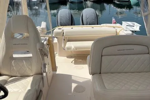 Slide: The Image of 2020 Grady-White Freedom 275 boat interior with cushioned seating and dual engines. - 8