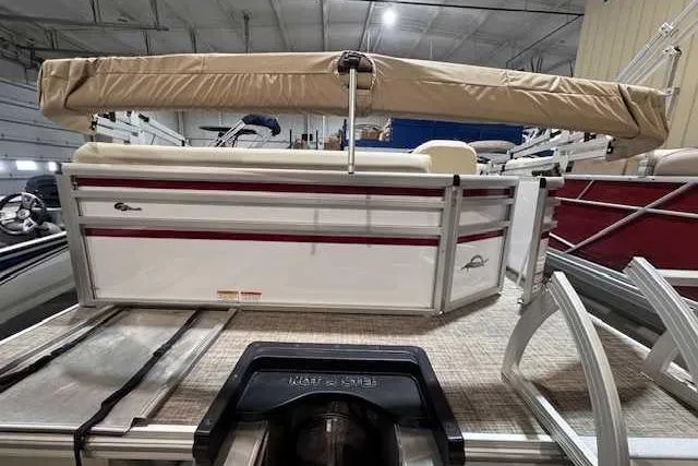 Slide: The Image of 2025 SunCatcher Select 16C pontoon boat with beige canopy in a showroom. - 2