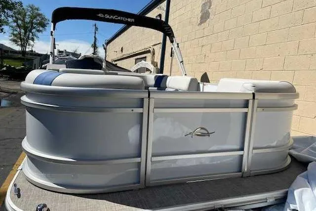 Slide: The Image of 2025 SunCatcher Select 18C pontoon boat, white exterior, docked near a brick wall. - 2
