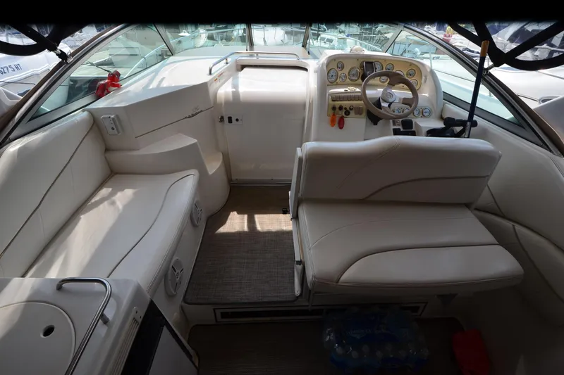 Slide: The Image of Interior of a 2000 Larson Cabrio 290 boat with beige seating and control panel. - 10
