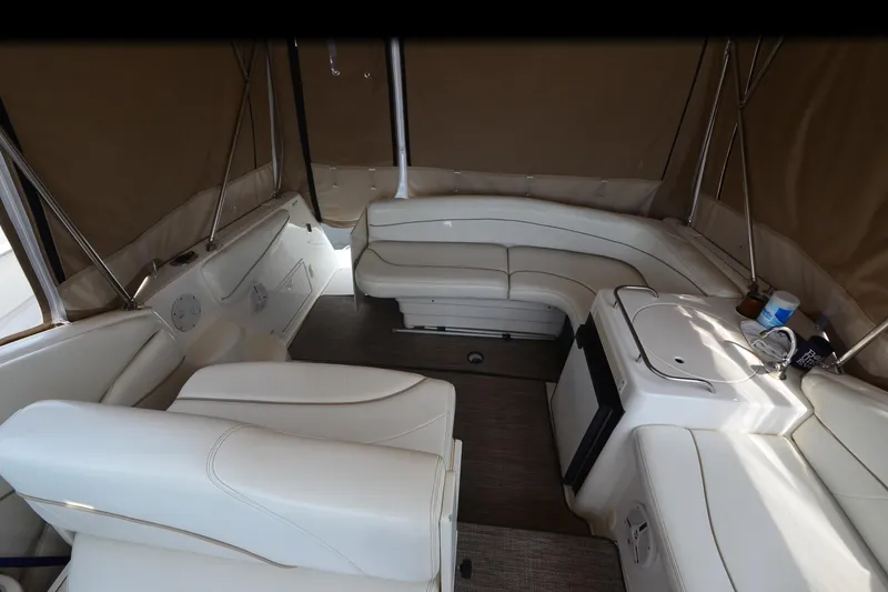 Slide: The Image of Interior of a 2000 Larson Cabrio 290 boat with white leather seating and compact kitchenette. - 11