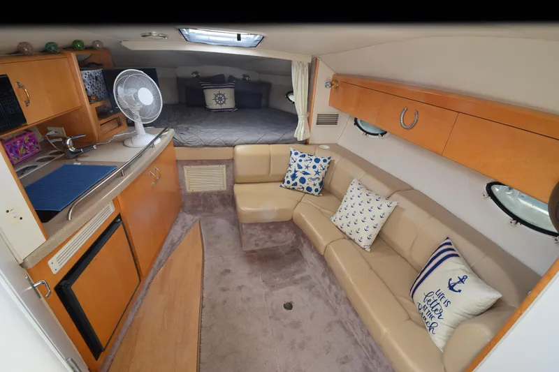 Slide: The Image of Interior of 2000 Larson Cabrio 290 boat with cozy seating and kitchenette. - 13
