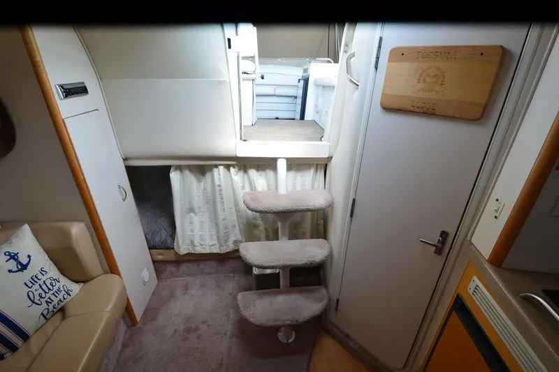 Slide: The Image of Interior of 2000 Larson Cabrio 290 boat with cozy seating and carpeted steps. - 16