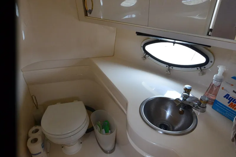 Slide: The Image of 2000 Larson Cabrio 290 boat bathroom with sink, toilet, and oval window. - 17