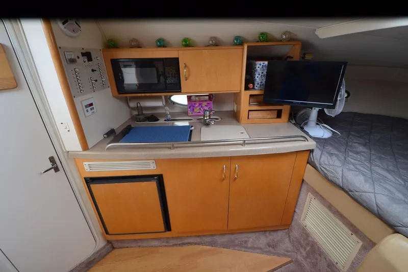Slide: The Image of 2000 Larson Cabrio 290 interior with kitchenette, microwave, TV, and bed. - 18