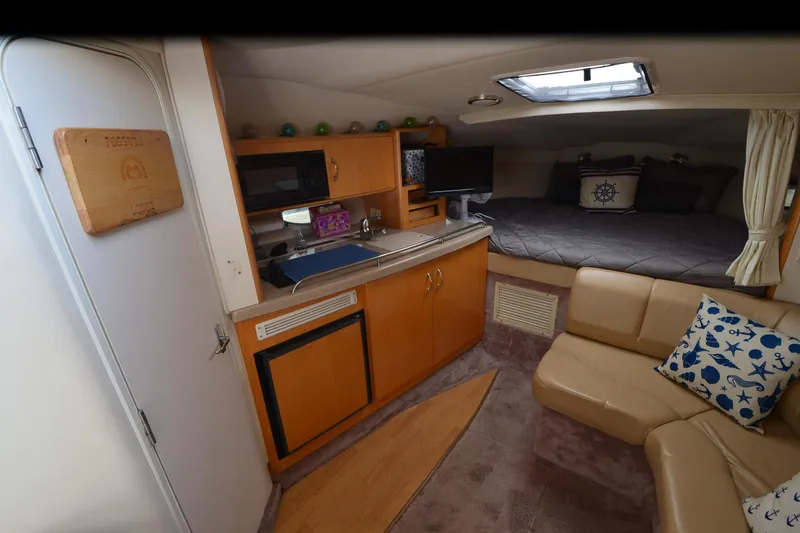 Slide: The Image of Interior of 2000 Larson Cabrio 290 boat with kitchenette, seating, and sleeping area. - 20