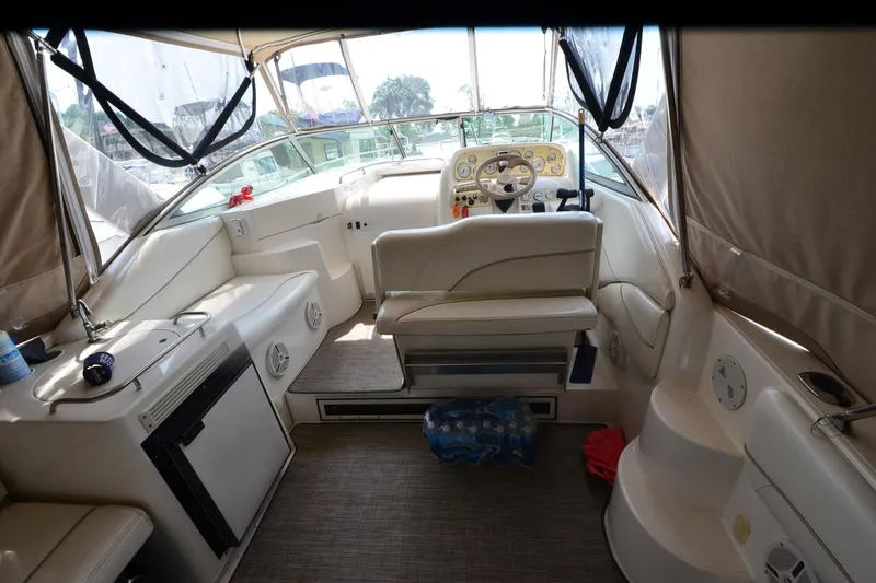Slide: The Image of Interior of a 2000 Larson Cabrio 290 boat, featuring a steering console and seating area. - 7