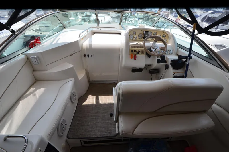 Slide: The Image of Interior of 2000 Larson Cabrio 290 boat with steering wheel and seating area. - 8