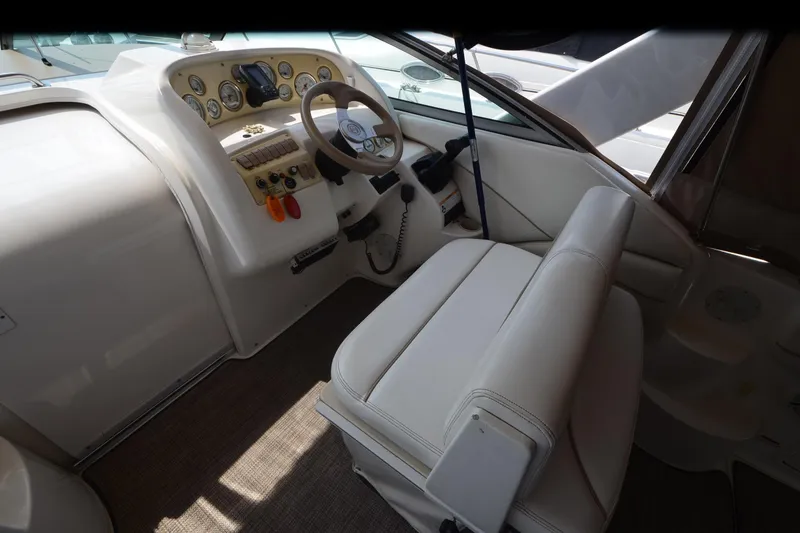 Slide: The Image of Interior of 2000 Larson Cabrio 290 boat showing steering wheel and dashboard controls. - 9