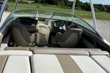 Slide: The Image of 2011 Sea Ray 210 SLX boat interior with seating and dashboard, parked outdoors. - 4