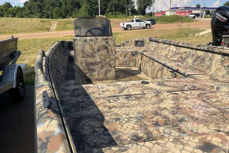 Slide: The Image of 2025 Excel 1751 River Warrior boat with camouflage design, parked outdoors. - 3