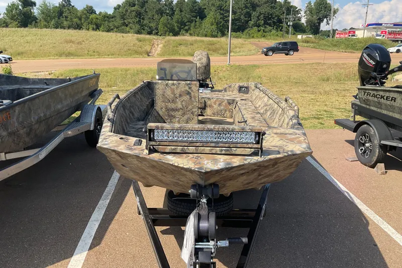 Slide: The Image of 2025 Excel 1751 River Warrior boat with camouflage design on a trailer in a parking lot. - 5