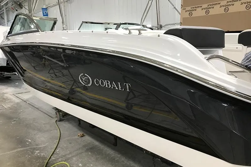 The Image of 2024 Cobalt 220S boat in showroom, sleek black and white design. - 1