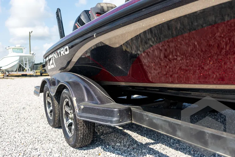 Slide: The Image of 2020 Nitro Z21 boat on trailer, parked on gravel lot under clear sky. - 12