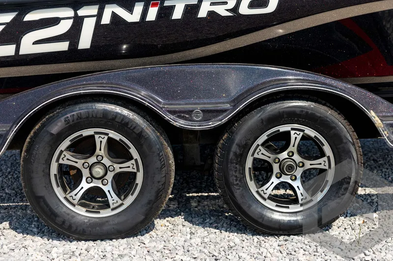 Slide: The Image of 2020 Nitro Z21 trailer wheels on gravel, showcasing sleek design and sturdy tires. - 14