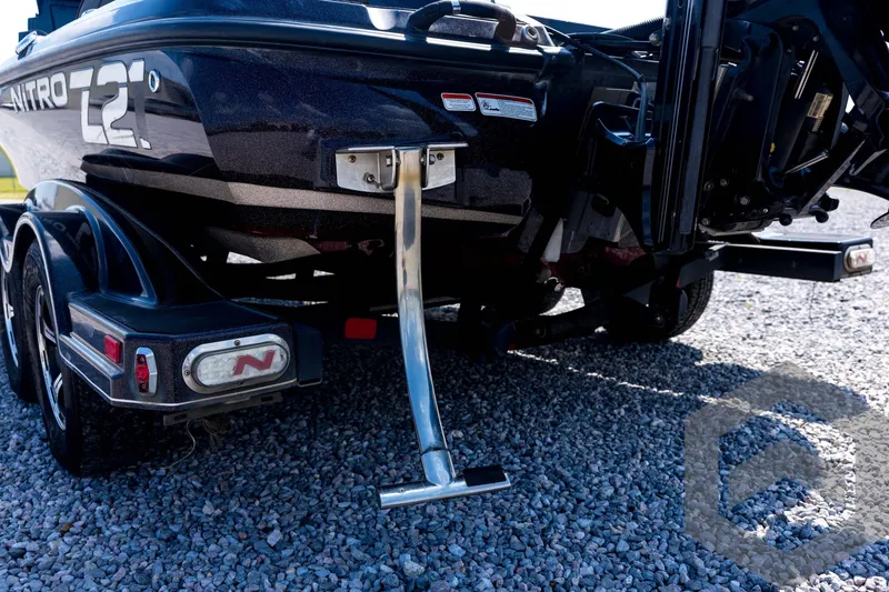 Slide: The Image of 2020 Nitro Z21 boat rear view on gravel, showcasing trailer and motor components. - 68