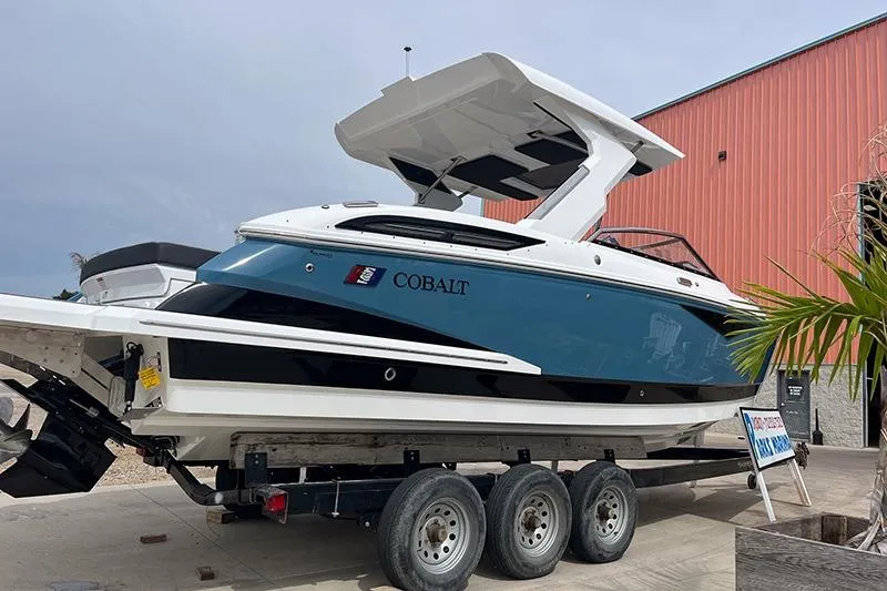 Slide: The Image of 2024 Cobalt A29 boat on trailer, blue and white design, parked near a building. - 3