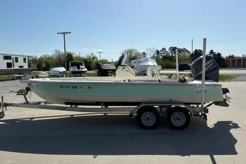 Slide: The Image of 2007 Scout 200 Bay Scout boat on trailer, parked outdoors in a sunny setting. - 2