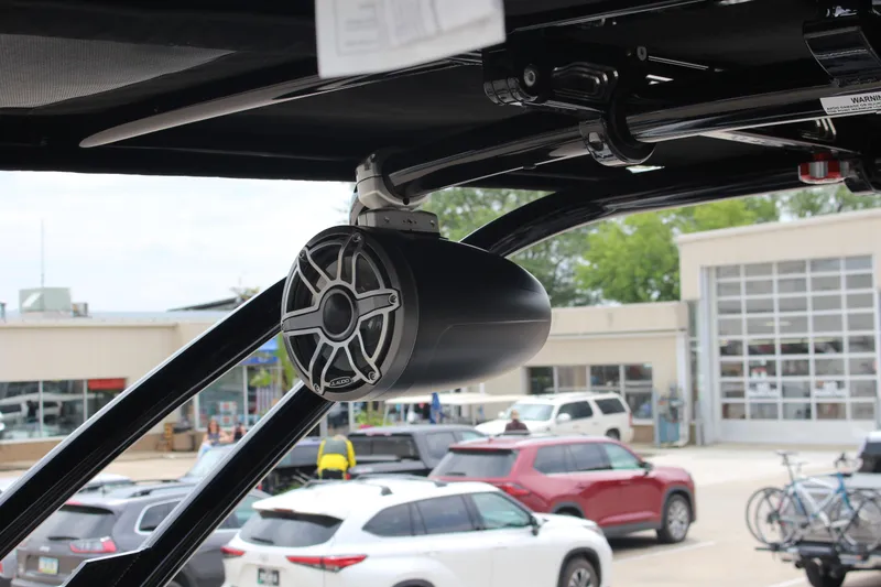 Slide: The Image of 2024 Cobalt R4 Surf boat with mounted speaker, parked in a dealership lot. - 10