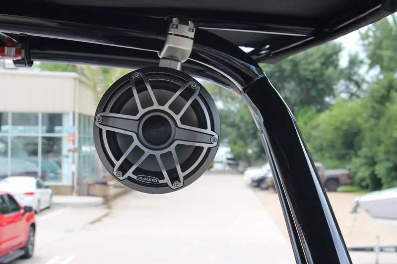 Slide: The Image of 2024 Cobalt R4 Surf boat with JL Audio speaker, outdoor setting. - 11