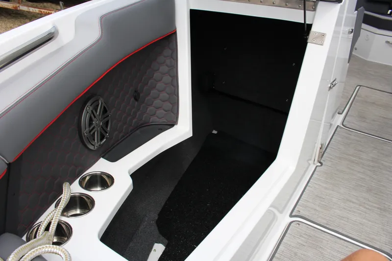 Slide: The Image of 2024 Cobalt R4 Surf boat interior with speaker, cup holders, and rope storage. - 19