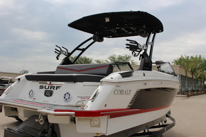 Slide: The Image of 2024 Cobalt R4 Surf boat with sleek design and modern features, docked outdoors. - 42