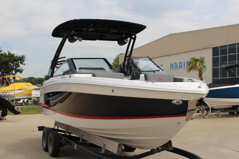 Slide: The Image of 2024 Cobalt R4 Surf boat on trailer, sleek design, black and white exterior. - 45