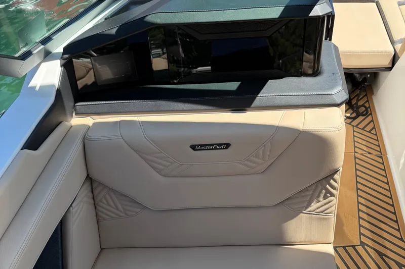 Slide: The Image of 2025 MasterCraft XStar 23 boat interior with beige seating and modern dashboard. - 10